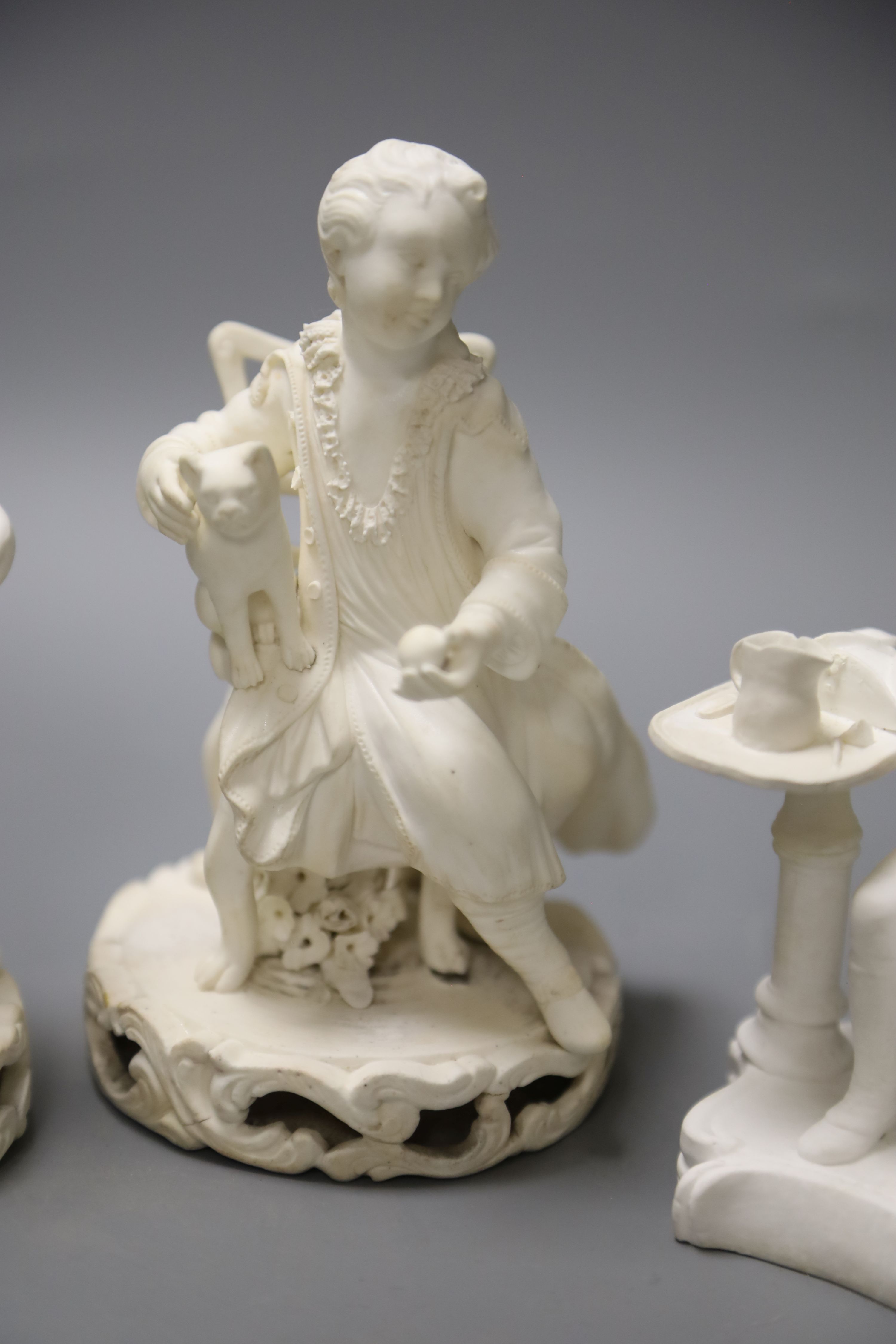 An early 19th century pair of Derby biscuit figures of a boy with a cat and a girl with a dog and a Minton figure of a Chelsea pensione